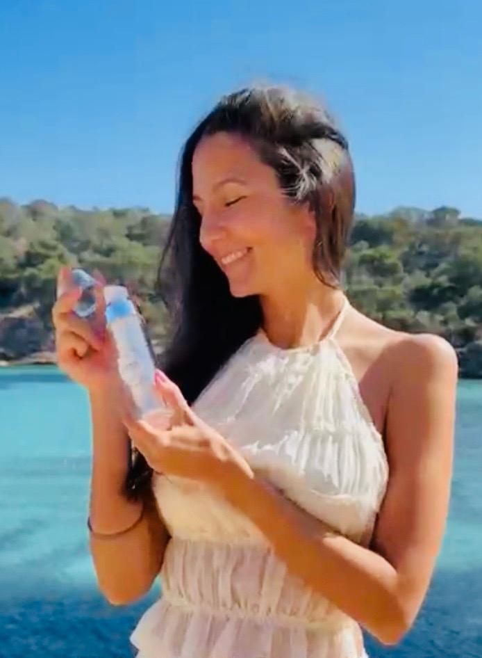 Frau mit AURALYS Flakon am Meer