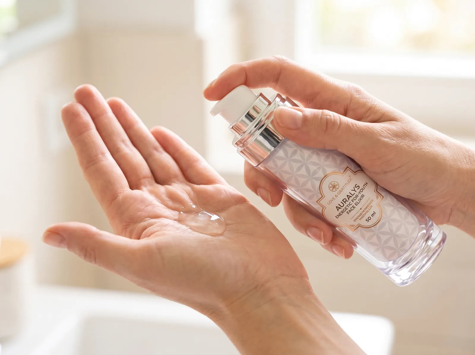 Zwei bis drei Pumpstöße klares Elixier in der Handfläche, daneben der Flakon